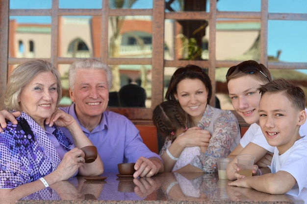 Foto familia feliz en la mesa al aire libre en verano