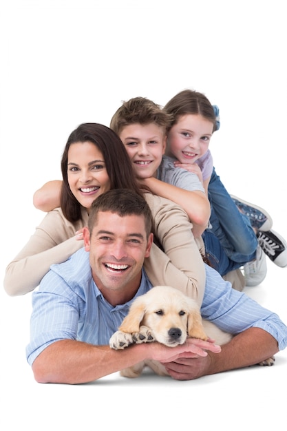 Familia feliz mintiendo uno encima del otro con perro