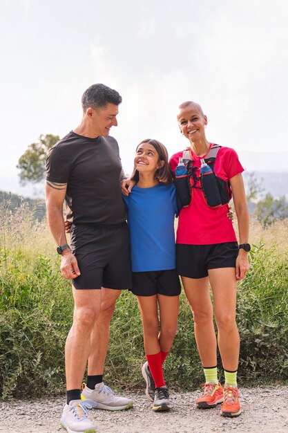 Foto familia feliz mirando a la cámara después de hacer deportes