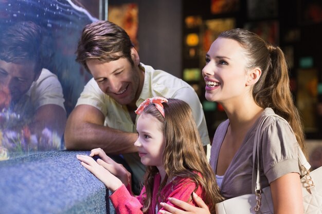 Familia feliz mirando el tanque de peces