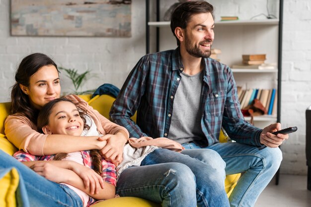 Foto familia feliz mirando la televisión