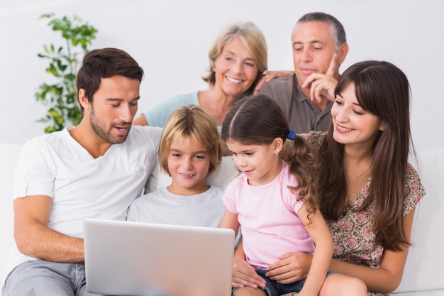 Familia feliz, mirar la computadora portátil