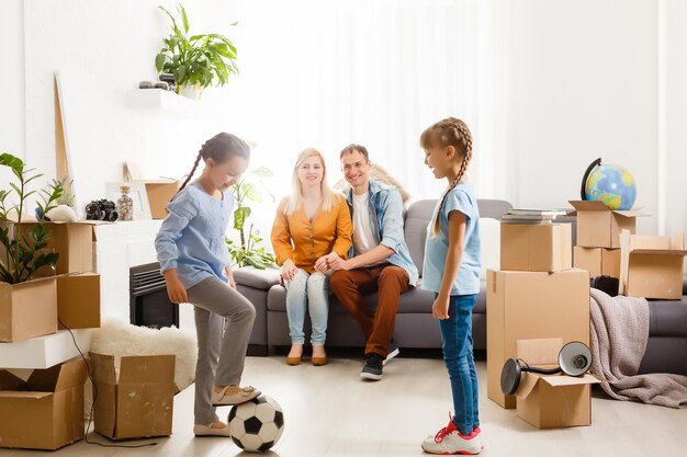 Familia feliz mudarse a casa con cajas alrededor