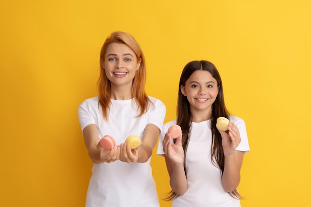 Familia feliz de mujer y niña adolescente tienen galletas de macarrón francés macarrón francés