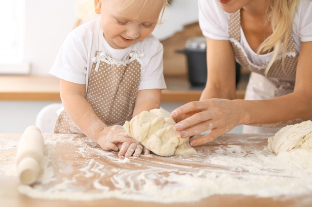 Família feliz na cozinha. Filha de mãe e filho cozinhando torta de férias ou biscoitos para o dia das mães, série de fotos de estilo de vida casual no interior da vida real