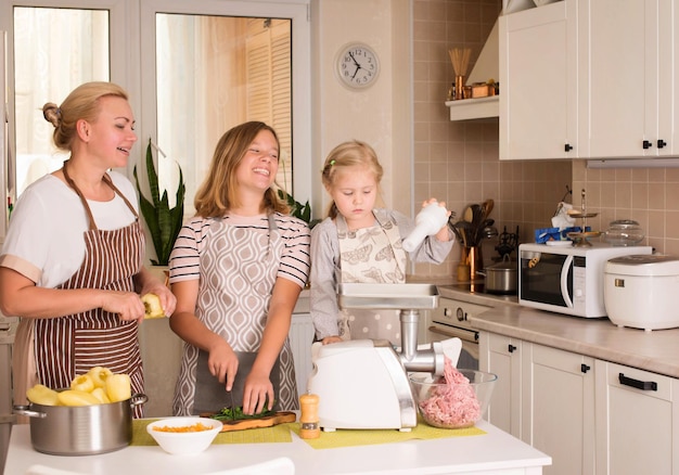 Família feliz na cozinha Mãe e filhas se divertindo cozinhando em casa Conceito de comida doméstica
