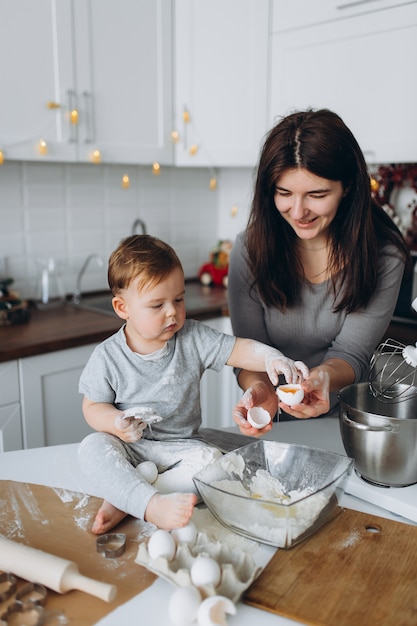 Família feliz na cozinha. mãe e filho a preparar a massa, assar biscoitos