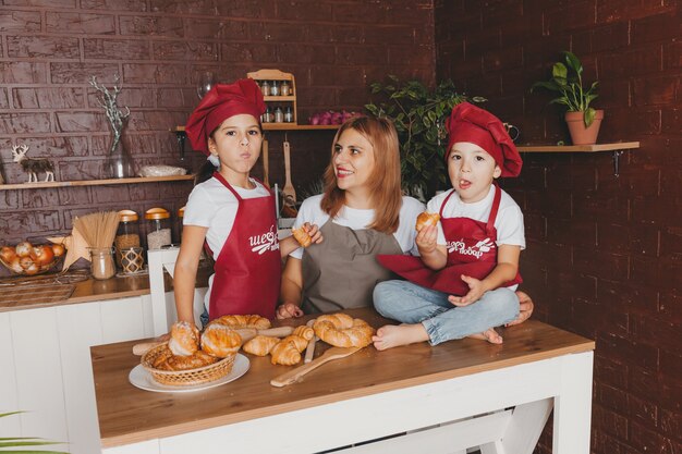 Família feliz na cozinha. mãe e filhos preparam massa, assam biscoitos. dia das Mães.