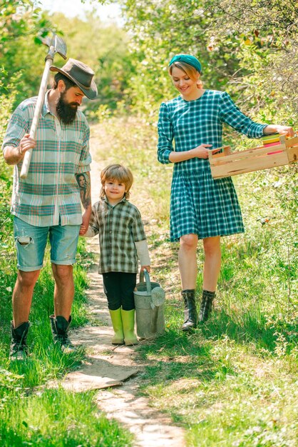 Família feliz na fazenda Dia da Terra Linda jovem família sorridente se divertindo no pátio da fazenda Conceito de terra