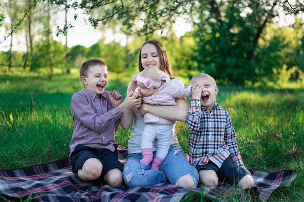 Família feliz na natureza. Filhos brincalhões com irmãs e mãe ao ar livre. Grande família.