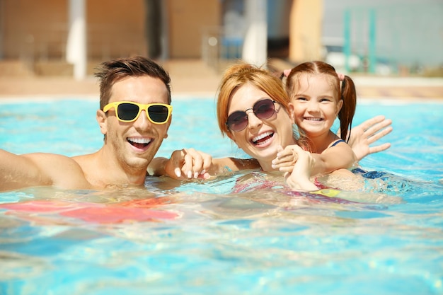 Família feliz na piscina do parque aquático