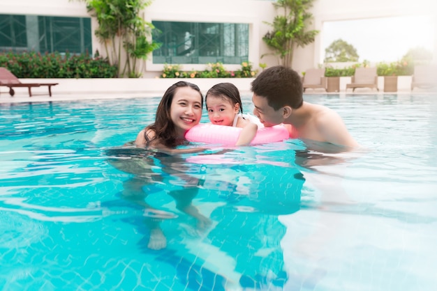 Foto família feliz na piscina. férias de verão e conceito de férias