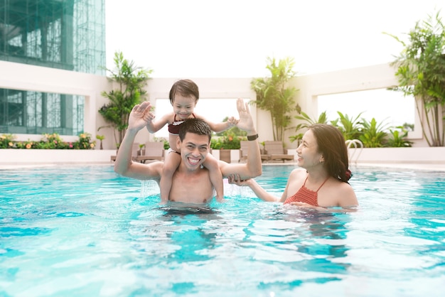 Foto família feliz na piscina. férias de verão e conceito de férias