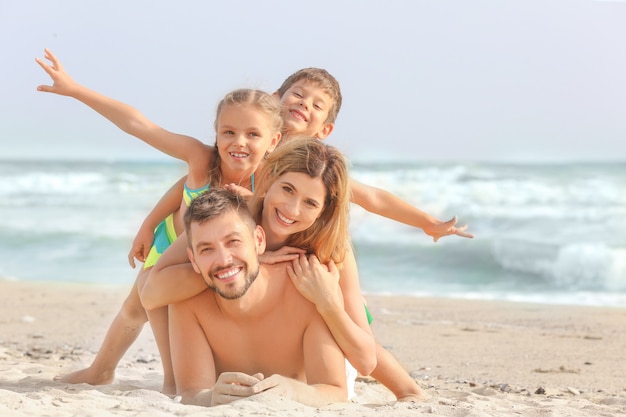 Família feliz na praia do mar no resort