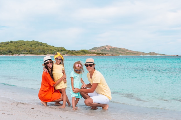 Família feliz na praia durante as férias de verão