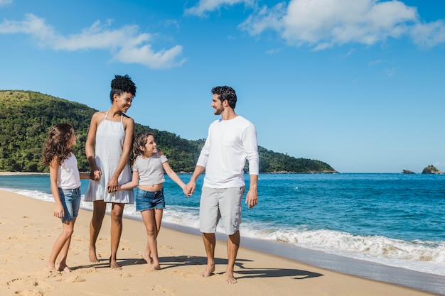 Família feliz na praia ensolarada