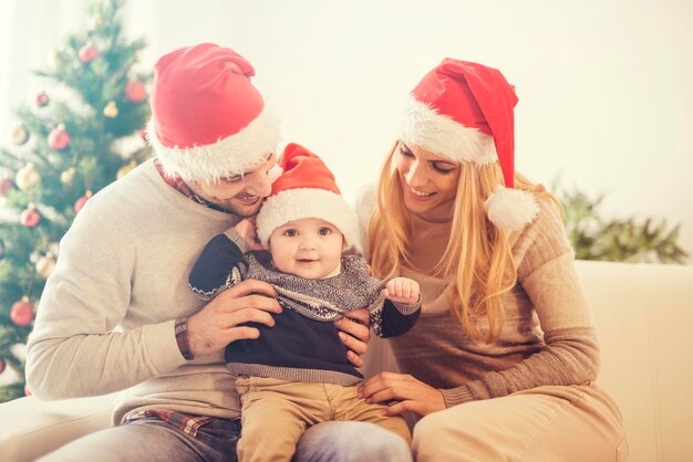 Família feliz na sala com a árvore de Natal