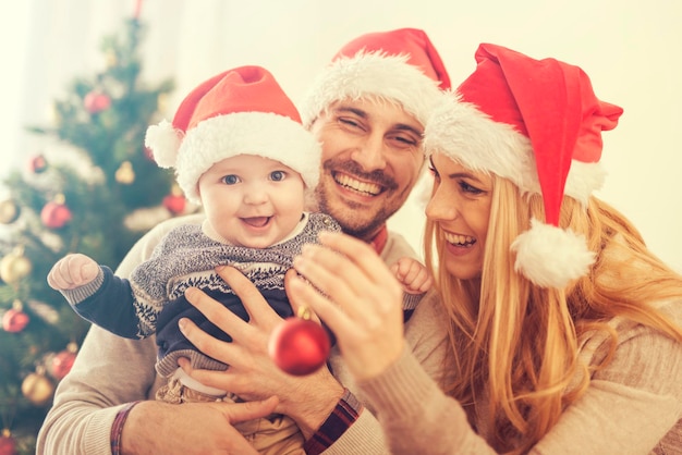 Família feliz na sala com a árvore de Natal