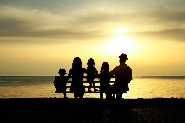 Una familia feliz en la naturaleza junto al mar en una silueta de viaje