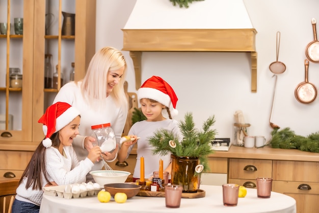 Familia feliz en navidad. Madre e hijas divirtiéndose en casa