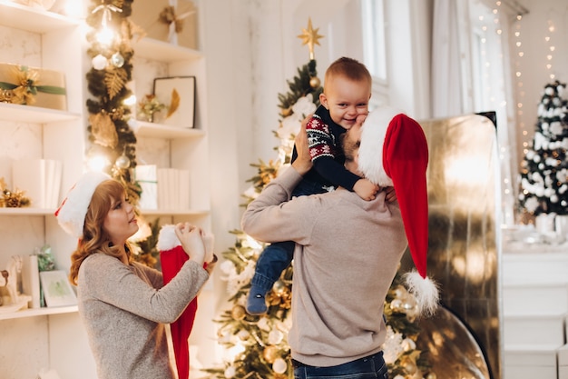 Familia feliz con el niño celebrando año nuevo juntos.