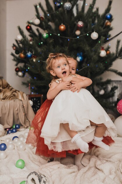 Familia feliz con el niño celebrando el año nuevo y la Navidad en el árbol de Navidad decorado y guirnaldas