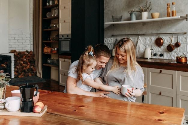 Familia feliz con un niño cocina y se ríe en la cocina