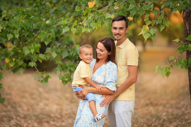 Familia feliz con un niño pequeño en un paseo por el parque