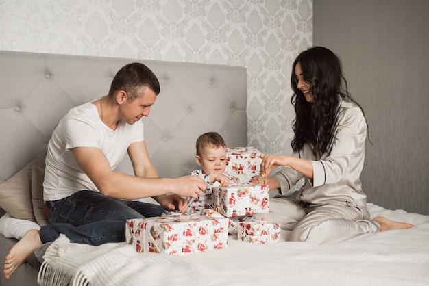 Familia feliz con niños celebrando el año nuevo y la Navidad en guirnaldas de árboles de Navidad decorados