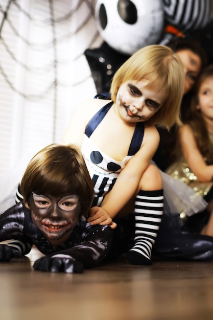 Familia feliz con niños en disfraces y maquillaje en celebración de Halloween