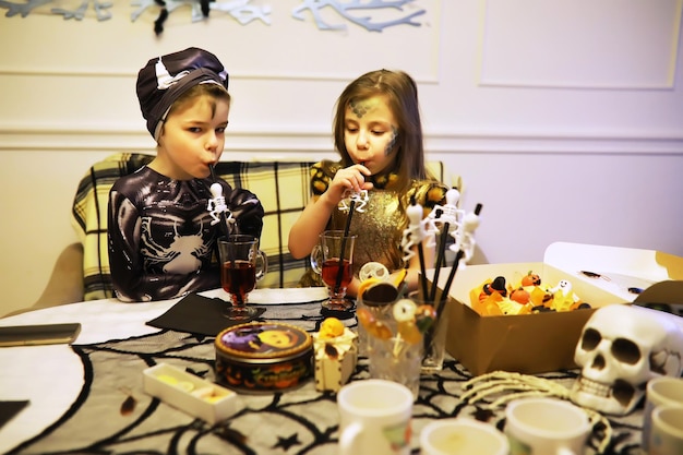 Familia feliz con niños en disfraces y maquillaje en celebración de Halloween