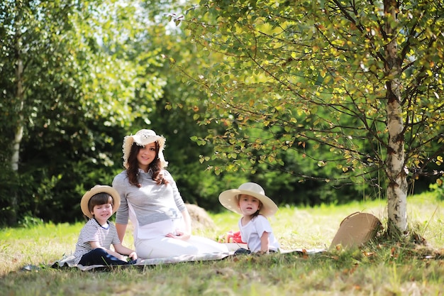 Familia feliz con niños haciendo un picnic en el parque padres con niños sentados en el césped del jardín y comiendo sandía al aire libre