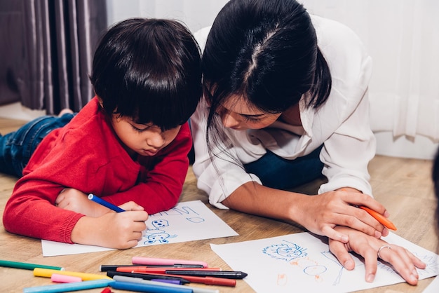 Familia feliz niños niño niño jardín de infantes pintura dibujo en educación de maestros de peper en sala de juegos interior