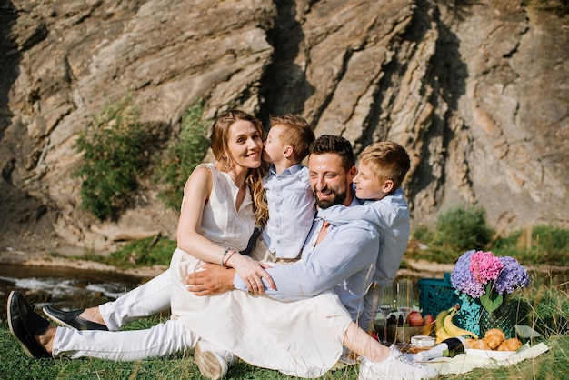 Familia feliz con niños en un picnic en el parque nacional junto al río