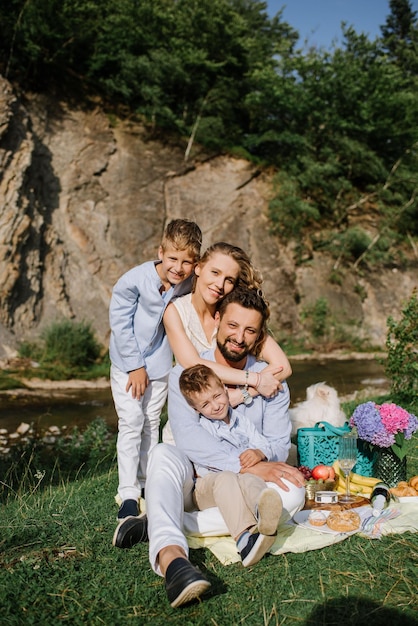 Foto familia feliz con niños en un picnic en el parque nacional junto al río