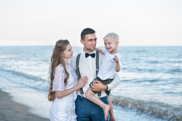 Familia feliz con niños en la playa tropical. Joven pareja hermosa con una linda bahía.