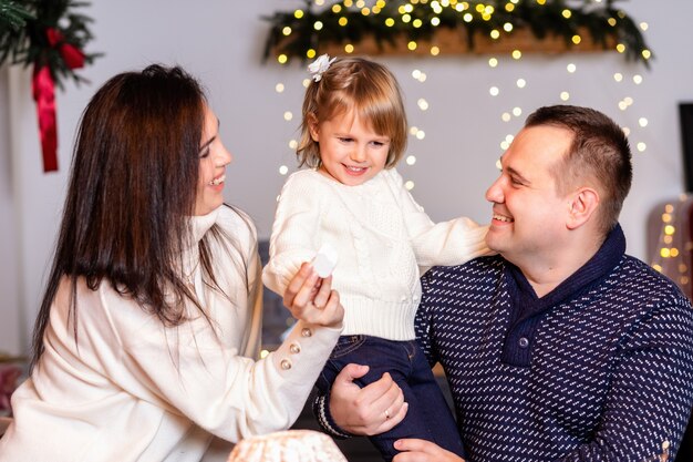 Familia feliz con niños rodando masa en la cocina de Navidad.