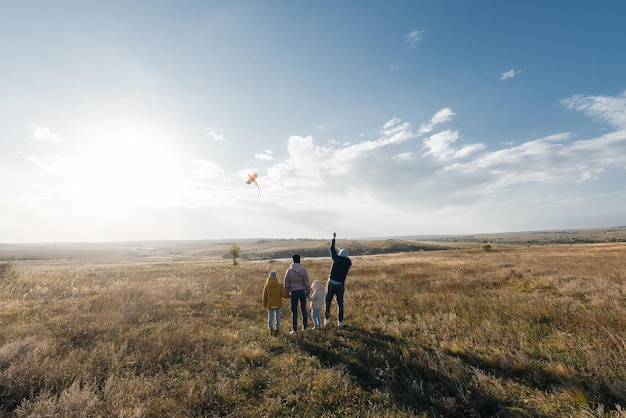 Una familia feliz con niños vuela una cometa y pasa tiempo juntos al aire libre en una reserva natural Infancia feliz y vacaciones en familia Libertad y espacio