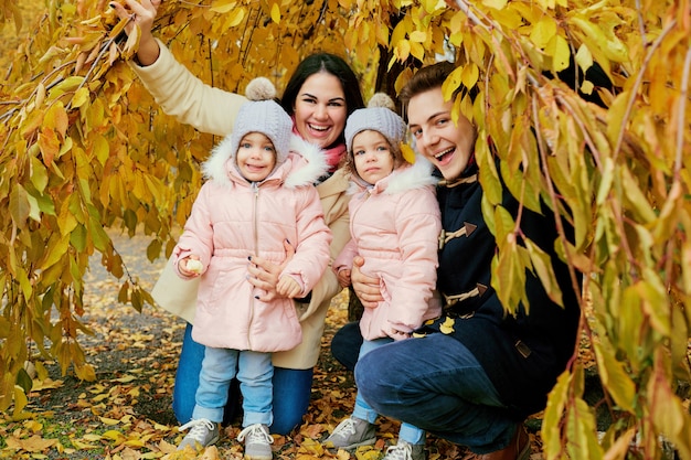 Família feliz no outono no parque.