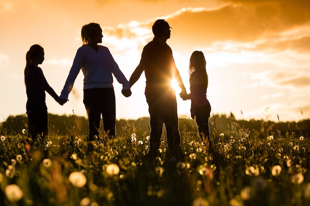 Família feliz no Prado ao pôr do sol