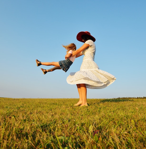 Família feliz no prado de verão bonito tendo tempo feliz circlin ao redor