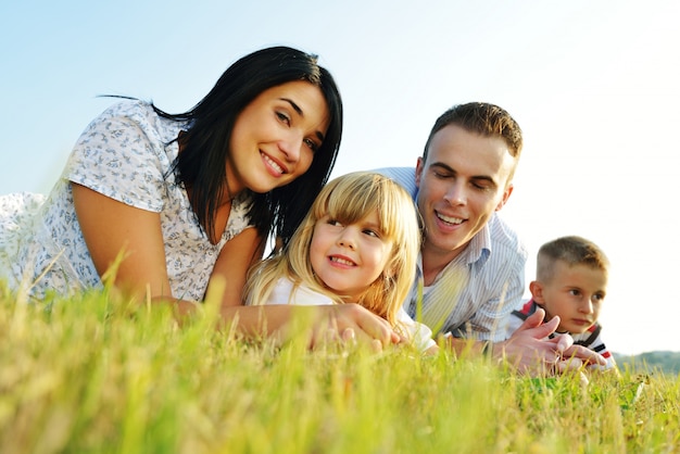 Família feliz no prado de verão bonito tendo tempo feliz