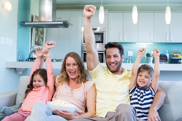 Família feliz no sofá assistindo tv