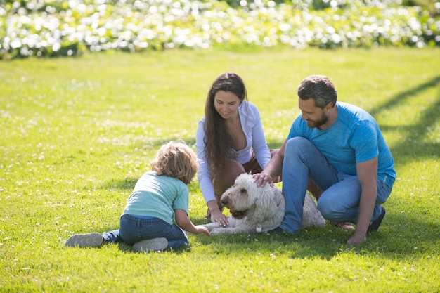 Família feliz no verão a pé, pai, mãe e filho, caminhando no parque e apreciando a bela n ...