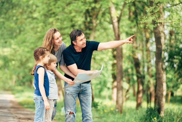 família feliz olhando mapas enquanto viaja no parque