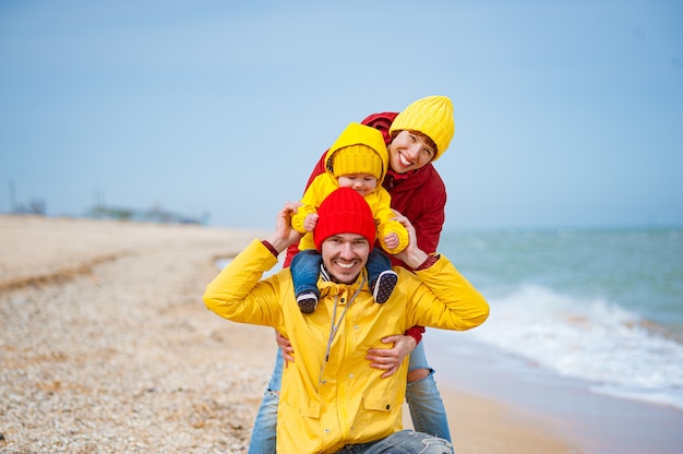 Familia feliz en la orilla del mar en invierno