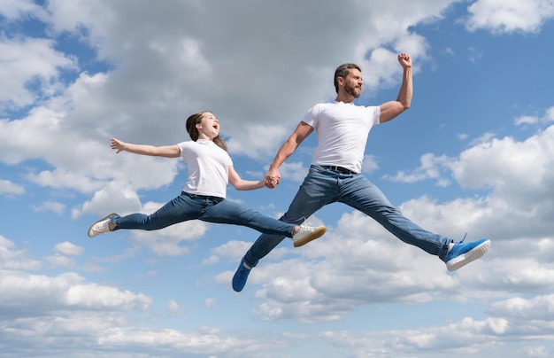 Familia feliz de padre e hija saltando en el cielo