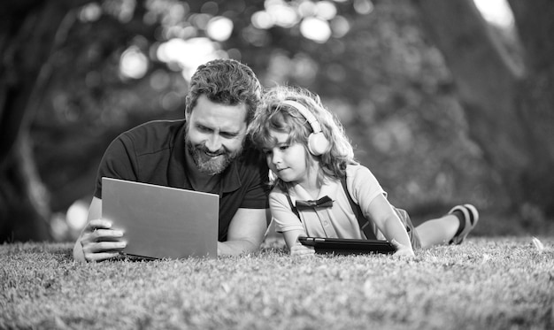 La familia feliz de padre e hijo usa una computadora portátil para videollamadas o lecciones de comunicación moderna