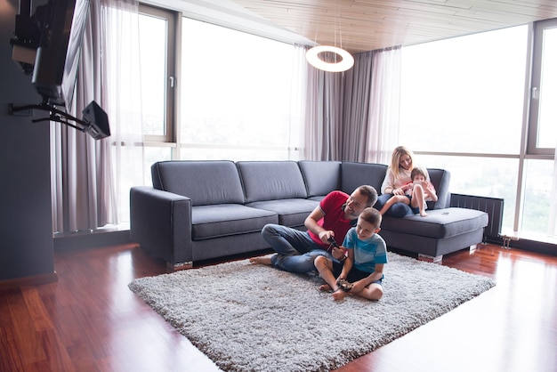 Foto familia feliz. padre, madre e hijos jugando videojuegos padre e hijo jugando videojuegos juntos en el suelo