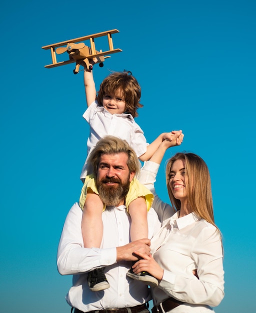 Família feliz Pai dando carona às crianças Mãe pai e filho filho na natureza no céu Garoto menino com avião de brinquedo